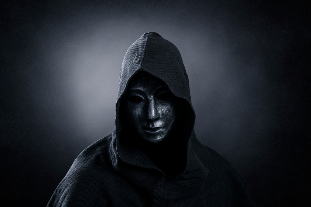 Dark hooded figure with mask symbolizing the aesthetic of the villain era