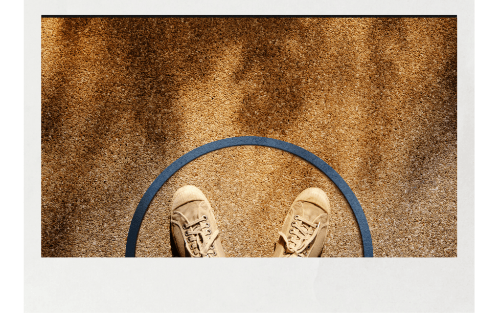 A pair of worn canvas shoes standing inside a blue circle on a sunlit textured floor, symbolizing personal boundaries and emotional space.