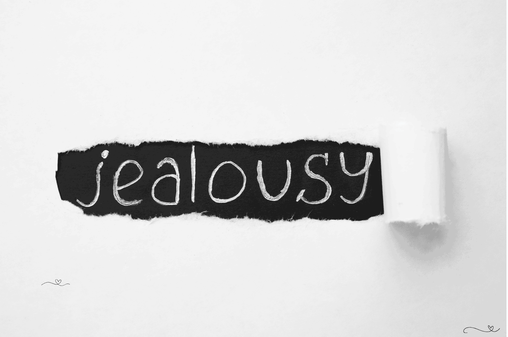 Why People Get Jealous - Word “jealousy” handwritten on black torn paper strip over white background
