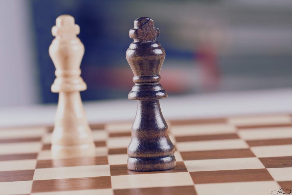 Narcissist relationship playbook -Two opposing chess kings, brown and tan,