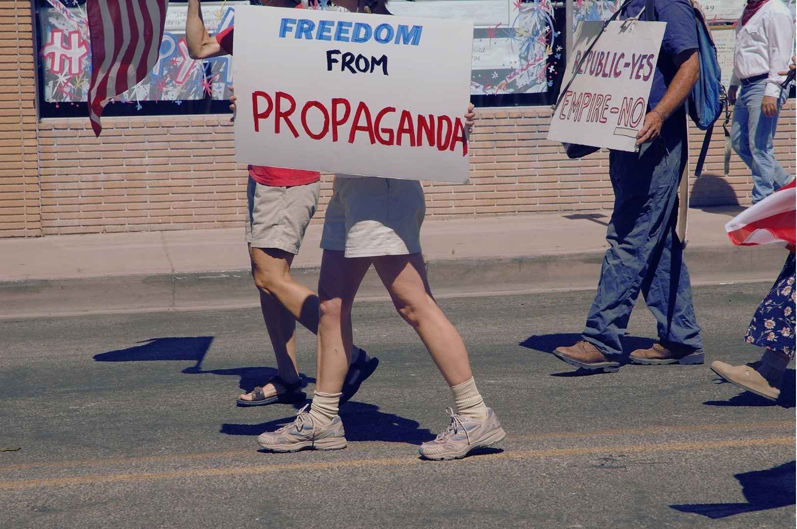 Israel social media propaganda- Protesters marching with anti-propaganda signs