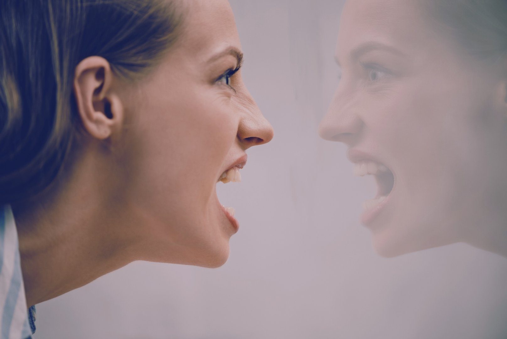 Microaggressions - A woman yelling at her reflection in a foggy mirror.