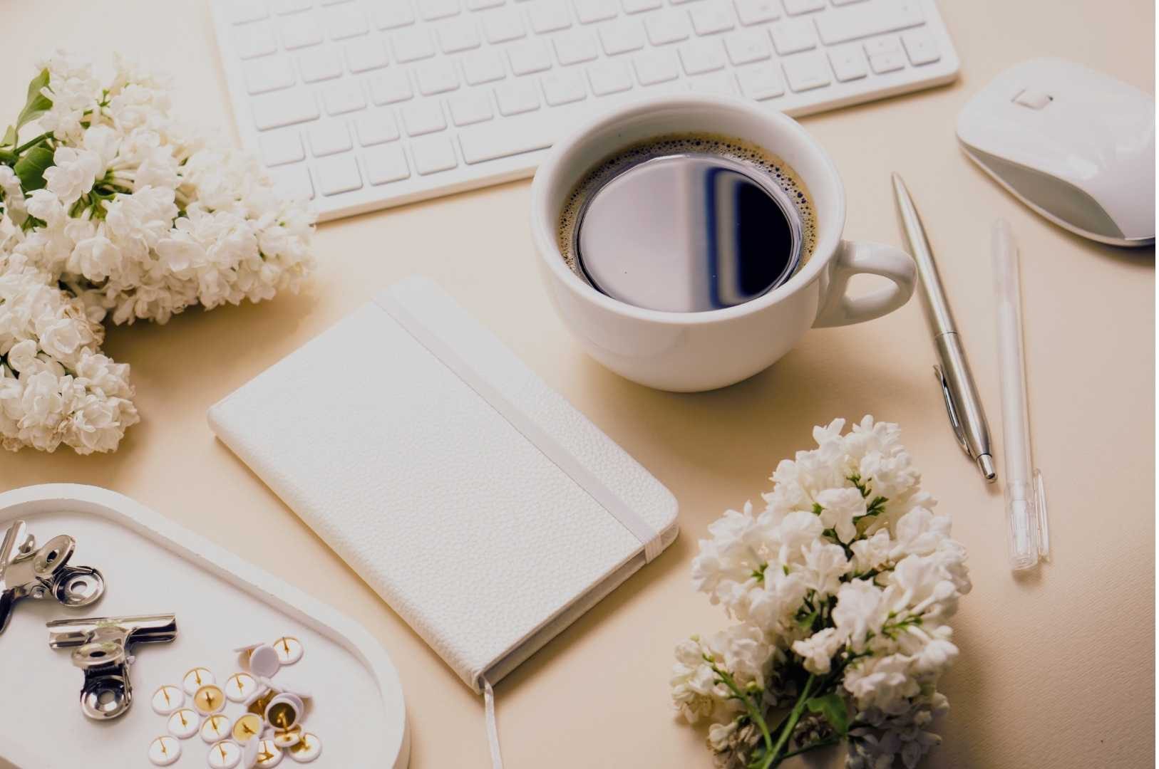 Mindfulness for people who hate Mondays – coffee break at work desk with flowers and notebook.
