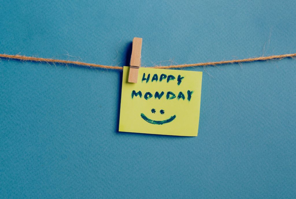 Mindfulness for people who hate Mondays – happy Monday sticky note on blue background.